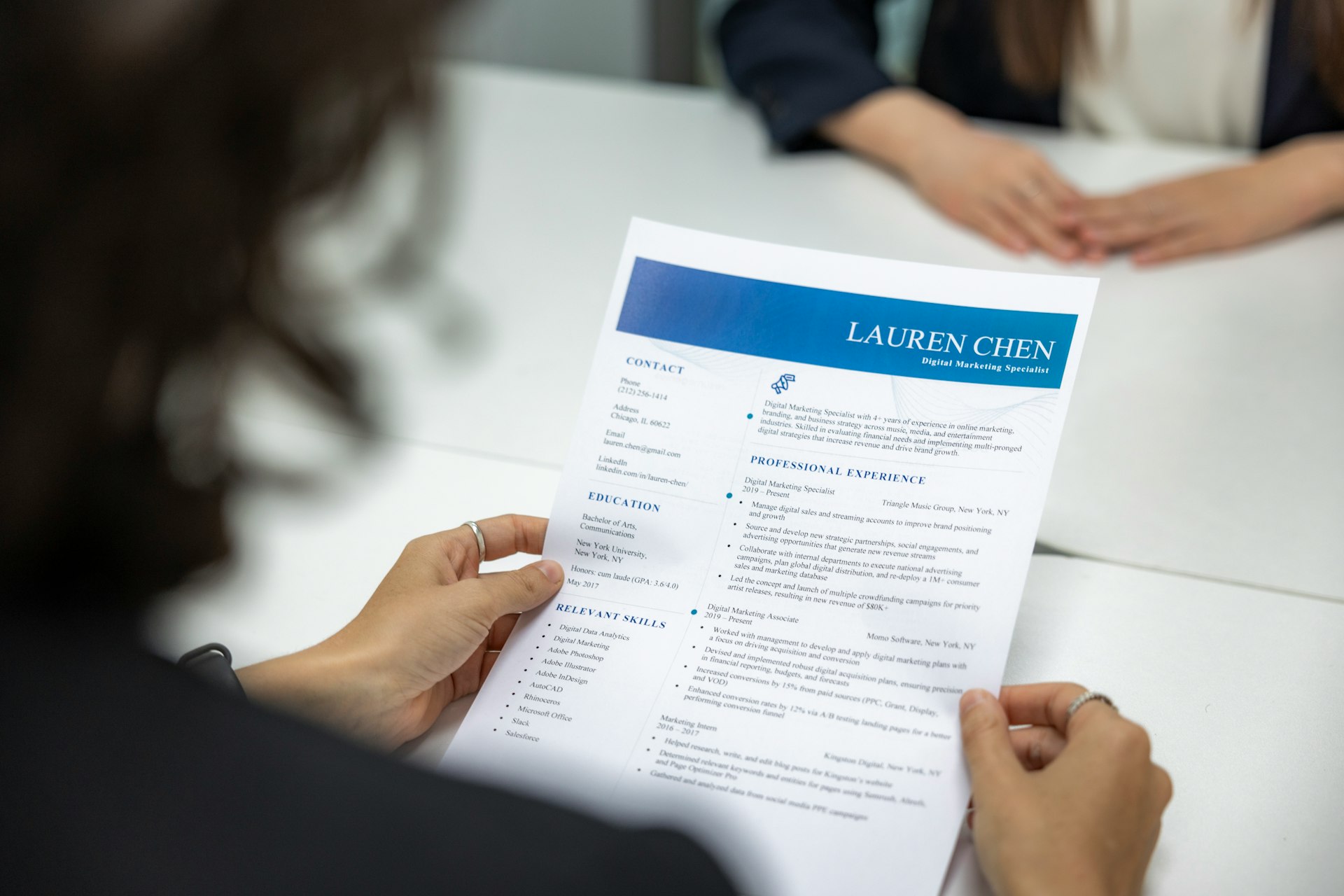 a woman is reading a resume at a table a woman is reading a resume at a table